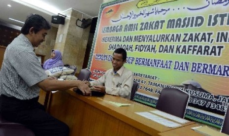 Jamaah membayar zakat fitrah.