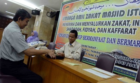   Jamaah membayar zakat fitrah di Masjid Istiqlal, Jakarta Pusat, Selasa (5/8).  (Republika/Agung Supriyanto)