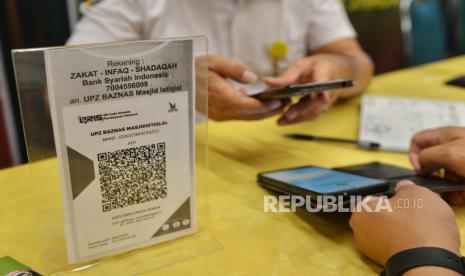 Jamaah membayar zakat fitrah melalui layanan Qris di Masjid Istiqlal, Jakarta, Sabtu (6/4/2024). Unit Pengumpul Zakat (UPZ) Baznas Masjid Istiqlal membuka layanan pembayaran zakat fitrah berupa 3,5 liter beras atau uang senilai Rp50.000 yang berlangsung hingga malam takbiran.