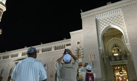 Jamaah mengambil gambar gerhana bulan di Masjid Nabawi, Madinah, Jumat (27/7) malam waktu setempat. Kesempatan langka itu digunakan jamaah haji tahun ini mengikuti shalat sunah Khusuf di masjid bersejarah tersebut.