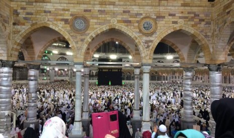 Jamaah umrah berswafoto dengan latar Kabah di Masjidil Haram.