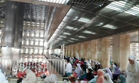 Jamaah wanita peserta Aksi 313 bersiap mengikuti Shalat Jumat di selasar selatan Masjid Istiqlal, Jumat (31/3).  