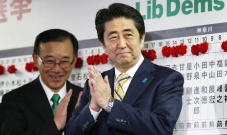 Japan's Prime Minister Shinzo Abe, who is also leader of the ruling Liberal Democratic Party (LDP), claps during an election night event at the LDP headquarters in Tokyo, December 14, 2014.