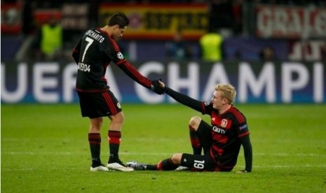 Javier Hernandez (kiri) menarik tangan rekannya Julian Brandt.