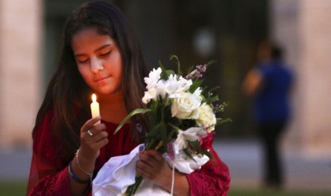 Jaxciri Solano menyalakan lilin saat peringatan mengenak korban penembakan di Odessa, Texas, Ahad (1/9).