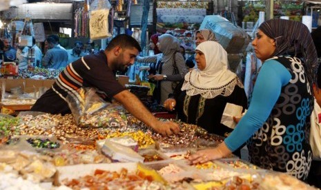  Jelang Ramadhan, warga memenuhi pasar tradisional di pusat kota Baghdad, Irak, Kamis (19/7).  (Karim Kadim/AP)