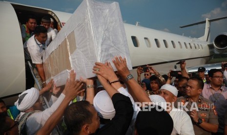 Jemaah membawa peti berisi jenazah Ustad Arifin Ilham yang baru tiba dari Penang, Malaysia di Bandara Halim Perdanakusuma, Jakarta Timur, Kamis (23/5/2019). 