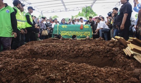 Jenazah korban pembunuhan Pulomas Dodi Triono siap dimasukan ke liang lahat pada proses pemakaman di TPU Tanah Kusir, Jakarta, Rabu (28/12). 