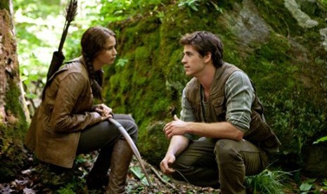 Jennifer Lawrence, kiri, memerankan Katniss Everdeen dan Liam Hemsworth sebagai Gale Hawthorne dalam sebuah adegan di 