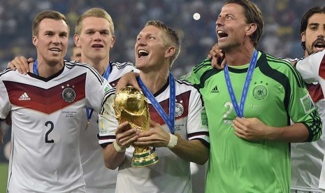 Jerman Bastian Schweinsteiger merayakan dengan trofi setelah Piala Dunia pertandingan sepak bola final antara Jerman dan Argentina di Stadion Maracana di Rio de Janeiro, Brasil, Minggu (13/7). (AP/Martin Meissner).