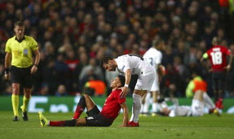 Jesse Lingard terduduk di lapangan menahan sakit.