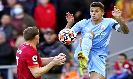 Joao Cancelo (kanan) dari Manchester City beraksi melawan James Milner (kiri) dari Liverpool selama pertandingan sepak bola Liga Premier Inggris antara Liverpool FC dan Manchester City di Liverpool, Inggris, 03 Oktober 2021.