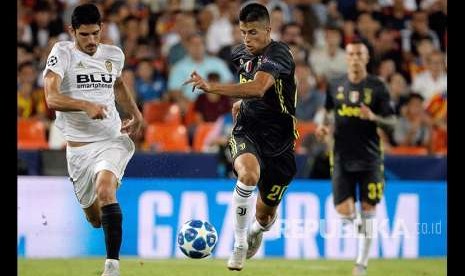 Joao Cancelo (kanan) dibayangi winger Valencia Guedespada (kiri) pertandingan Grup H Liga Champions antara Valencia melawan Juventus di Stadion Mestala, Valencia, Spanyol, Kamis (20/19) waktu setempat.