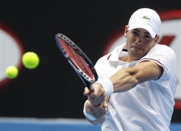  John Isner, petenis Amerika Serikat, melepaskan pukulan backhand saat menghadapi petenis Spanyol, Feliciano Lopez, di putaran ketiga turnamen Australia Terbuka di Melbourne, Australia, Jumat (20/1). 