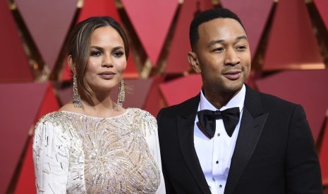 John Legend (kanan) dan istrinya Chrissy Teigen di karpet merah Piala Oscar, (27/2).