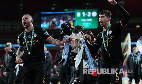 John Stones (kanan) dan Kyle Walker mengangkat trofi Carabao Cup atau Piala Liga Inggris setelah pada laga final mengalahkan Aston Villa di Stadion Wembley, London, Inggris, Senin (2/3) dini hari.