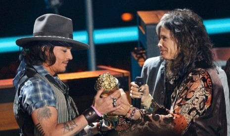 Johny Depp saat memberikan popcorn emas ke vokalis Aerosmith, Steve Tyler di ajang MTV Music Awards.