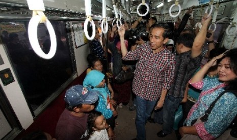 Joko Widodo berbincang dengan penumpang saat naik KRL menuju Depok di stasiun Tanah Abang, Jakarta, Senin (2/4).