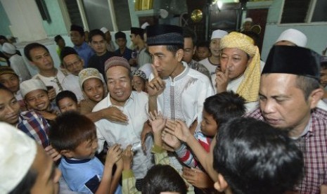 Joko Widodo (ketiga kanan) meminta anak-anak untuk tenang usai menunaikan ibadah shalat Taraweh pada malam pertama bulan Ramadan 1435 H di Masjid Ali Akbar, Sidosermo, Surabaya, Jawa Timur, Sabtu (28/6). 