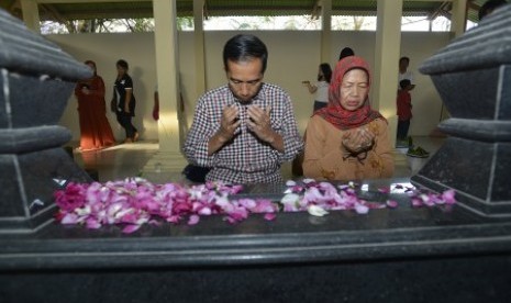 Joko Widodo (kiri) bersama Ibunda Sujiatmi Notomihardjo (kanan) memanjatkan doa untuk Ayahanda Alm. Widjiatno Notomihardjo saat ziarah makam di Tempat Pemakaman Keluarga, di Desa Gedangrejo, Karanganyar, Jawa Tengah, Sabtu (14/6).