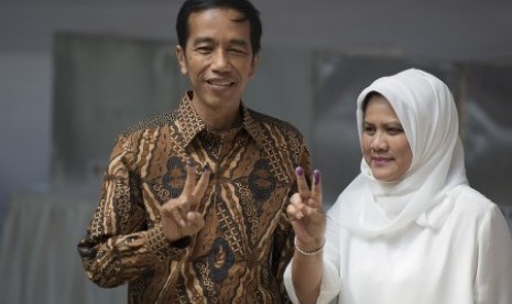 Joko Widodo (kiri) dan Isteri Ny Iriana (kanan) menunjukkan jari tangannya yang sudah tertoreh tinta pemilu usai mencoblos surat suara di TPS Nomor 18, Kelurahan Menteng, Jakarta Pusat, Rabu (9/7). 