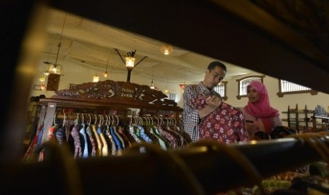 Joko Widodo (kiri) memilih sejumlah kemeja batik khas Cirebon untuk dibeli ketika berkunjung ke Pusat Batik Trusmi, Cirebon, Jawa Barat, Rabu (18/6). 