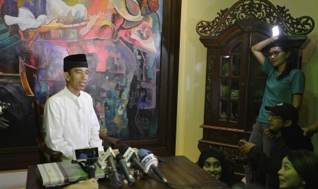 Joko Widodo (kiri) mengucapkan Selamat Hari Raya Idul Fitri 1435 H ketika rekaman gambar dengan sejumlah stasiun televisi di kediamannya di kawasan Sumber, Kota Surakarta, Jawa Tengah, Sabtu (26/7) malam. 