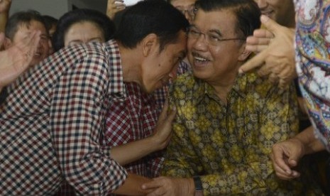 Joko Widodo (kiri) menyalami Jusuf Kalla (kanan)