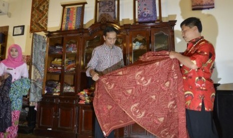  Joko Widodo (tengah) didampingi Bupati Cirebon Sunjaya Purwadi (kanan) melihat kain batik khas Cirebon di sela-sela kampanye di Pusat Batik Trusmi, Cirebon, Jawa Barat, Rabu (18/6). 