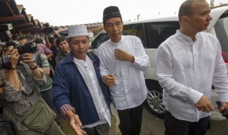 Joko Widodo (tengah) didampingi ketua rombongan Umrah Usamah Hisyam (kiri), berjalan menuju terminal keberangkatan saat akan menunaikan ibadah Umrah di terminal 2D Bandara Soekarno-Hatta, Tangerang, Banten, Ahad (6/7). 