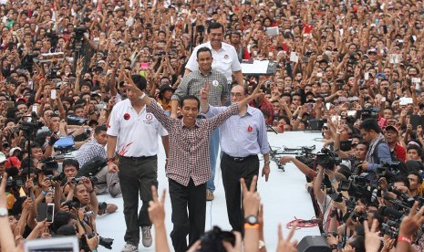 Joko Widodo (tengah) didampingi Tim pemenangan Capres Jokowi-JK Maruarar Sirait (kiri), Anis Baswedan (kedua belakang), Luhut Panjaitan (belakang) dan Tim pengarah Pemenangan Jokowi-JK Alwi Shihab (kanan) melambaikan dua jari kepada pendukungnya ketika Kon