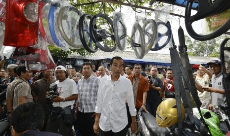 Joko Widodo (tengah) melakukan kunjungan ke Pasar Klithikan Notoharjo, Semanggi, Kota Surakarta, Jawa Tengah, Sabtu (26/7). 