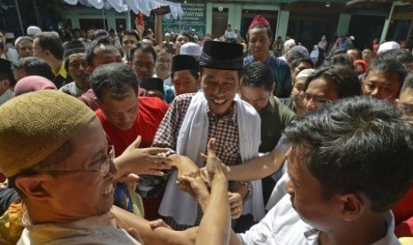  Joko Widodo (tengah) menyalami warga usai menunaikan ibadah Shalat Jumat di Masjid Pondok Pesantren Al Muayyad, Surakarta, Jawa Tengah, Jumat (20/6).