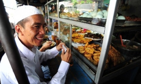 Jokowi berbaur dengan masyarakat menikmati makan siang seusai menunaikan ibadah shalat Jumat di Masjid Agung Sunda Kelapa, Jakarta Pusat, Jumat (6/4).