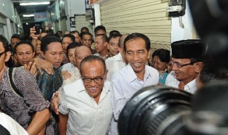 Jokowi dan Ketua Umum Partai Golkar Aburizal Bakrie saat mengunjungi pasar Gembrong di Cempaka Putih, Jakarta, Selasa (13/5).