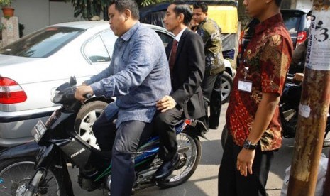 Jokowi dibonceng sepeda motor tidak menggunakan helm.