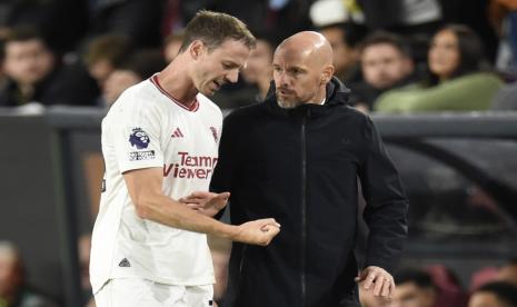 Jonny Evans (kiri) bersama pelatih Manchester United Erik ten Hag.