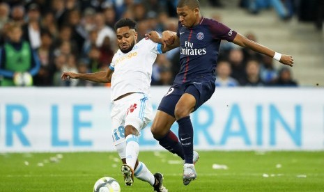 Jordan Amavi (kiri) dari Olympique Marseille mencoba menghalangi pemain Paris Saint-Germain Kylian Mbappe (kanan) pada pertandingan Ligue 1 antara kedua tim di Stadion Velodrome, Marseille, Prancis, Ahad (22/10).