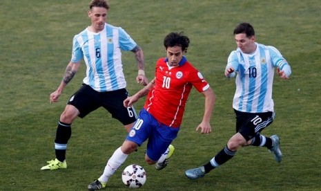 Jorge Valdivia membawa bola diapit Lucas Biglia (kiri) dan Lionel Messi pada final Copa America 2015.