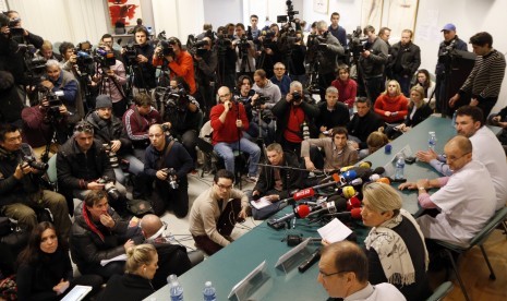 Journalists surround a table where medical team (on the right side) attend a news conference at the CHU hospital emergency unit in Grenoble, French Alps, where retired seven-times Formula One world champion Michael Schumacher is hospitalized after a ski ac