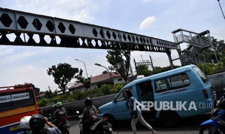 JPO Pasar Minggu. Warga dan pengendara motor melintas di dekat Jembatan Penyeberangan Orang (JPO) yang rusak di Pasar Minggu, Jakarta Selatan, Senin (4/3/2019). 