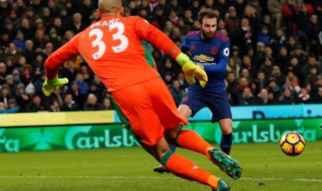 Juan Mata (kanan) membuang peluang emas saat hanya berhadapan dengan kiper Stoke City Lee Grant.