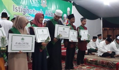 Juara I Musabaqah Tilawatil Quran (MTQ) tingkat Sekolah Lanjutan Tingkat Atas (SLTA) menerima hadiah paket umrah dalam acara Istighosah Akbar Habaib dan Ulama se-Jabodetabek dan Grand Final MTQ di Pondok Pesantren Al Hamid, Cilangkap, Jakarta Timur, Sabtu (21/4) malam. 