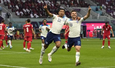 Jude Bellingham dari Inggris (tengah) merayakan dengan Mason Mount dari Inggris setelah mencetak gol pembuka timnya selama pertandingan sepak bola grup B Piala Dunia antara Inggris dan Iran di Stadion Internasional Khalifa di Doha, Qatar, Senin (21/11/2022).. 