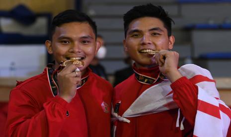 Judoka DKI Jakarta Gregory Ignacito Pantouw (kanan) dan kakaknya Gerald George Pantouw (kiri) berpose menggigit medali emas yang mereka raih dari ajang PON XX Papua. Gregory berjaya di nomor -90 kg, sementara Gerald juara di nomor -81 kg.