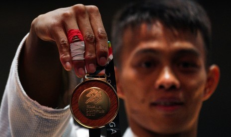 Judoka Indonesia asal Jawa Barat Iksan Apriyadi menunjukkan medali emas usai menjuarai final judo -73 Kg putra SEA Games XXIX Kuala Lumpur di KLCC, Kuala Lumpur, Malaysia, Sabtu (26/8). 