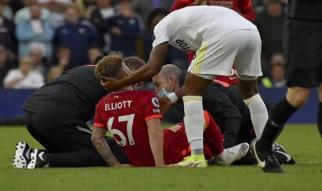 Junior Firpo Leeds United memegang kepala pemain Liverpool Harvey Elliott yang dibantu setelah ia cedera dalam bentrokan dengan Pascal Struijk dari Leeds United selama pertandingan sepak bola Liga Premier Inggris antara Leeds United dan Liverpool di Elland Road, Leeds, Inggris, Minggu, 12 September , 2021.