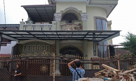 Jurnalis membuat liputan di depan rumah Kasat Narkoba Polres Pelabuhan Belawan AKP Ichwan Lubis, di Jalan Tuasan Medan, Sumatera Utara, Senin (25/4).