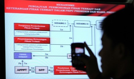 Jurnalis memotret layar tampilan mekanisme pengajuan kasus saat acara koordinasi penyelesaian perkara perselisihan hasil Pilpres 2014-2019 di Gedung MK Jakarta, Rabu (16/7).