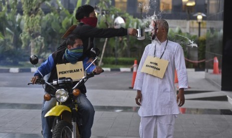 Jurnalis yang tergabung dalam Jurnalis Antikorupsi melakukan teatrikal penyiraman air keras terhadap Novel Baswedan saat melakukan aksi damai di halaman gedung KPK, Jakarta, Selasa (20/6).